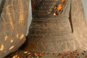 Primer plano de la pieza de cerámica 'Light of Andalusia' de Pablo Tito, mostrando el minucioso grabado calado y relieves de estilo hispanomusulmán iluminados desde el interior.